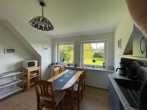 a kitchen with a table and chairs in a room at Ostseehuus Apartment II in Steinberg +21 photos