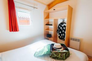 a bedroom with a bed with a suitcase on it at Camping Le Malazéou Wellness Sport Camping in Ax-les-Thermes +48 photos