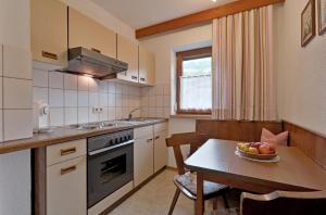 阿紹的住宿－Apartment Alpin，一间带桌子的小厨房和一间餐厅
