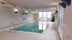 ein Schwimmbad in einem Gebäude mit Pool in der Unterkunft Residenz Hohe Lith Wohnung 04 01 in Cuxhaven