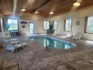 a pool in a room with a table and chairs at Horizon Inn & Suites in West Point