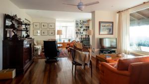 een woonkamer met een bank, stoelen en een tv bij Casa San Caetano 1 in Porto do Son