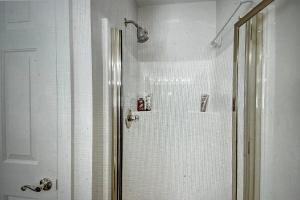 默特尔比奇Its JTs的浴室配有白色瓷砖墙壁的淋浴