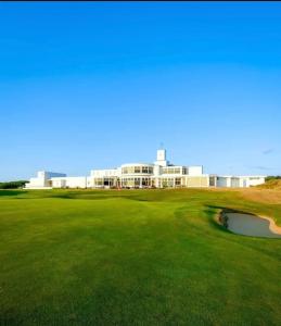 un campo da golf con un edificio sullo sfondo di Birkdale's Hidden Gem a Southport