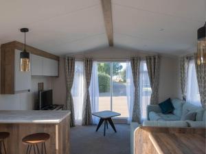 une cuisine et un salon avec un canapé et une table dans l'établissement Pinewoods Park Classic no.3 - sleeps 6 – no dogs, à Wells-next-the-Sea