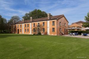 a large brick building with a large grass yard at Agriturismo Ca' Guerriera in Sustinente