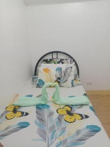 un letto con copriletto e uccelli sopra di Mactan Oasis gardens condominium a Lapu Lapu City