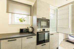 a kitchen with white cabinets and a window at Vakantiewoning De Ketten in Schoppem