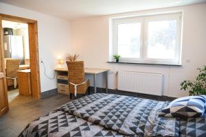a bedroom with a bed and a desk and a window at Stilvolle Auszeit auf der schwäbischen Alb in Sonnenbühl