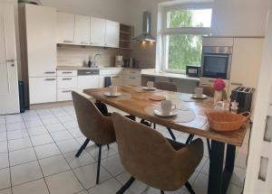 a kitchen with a wooden table and chairs in it at Gemütliche Ferienwohnung im Herzen von Hameln in Hameln +5 photos