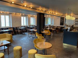 a restaurant with tables and chairs in a room at Hotel Tari in Würzburg