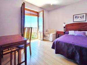 Un dormitorio con una cama, una mesa y una silla. en Hospedaje La Judería, en Segovia