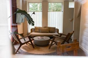 a living room with a couch and two chairs at de Wever Lodge in Otterlo