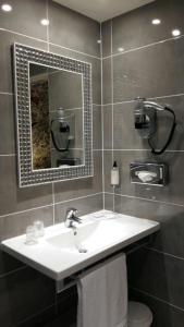 y baño con lavabo y espejo. en Hotel Best Western Anjou Lafayette en París