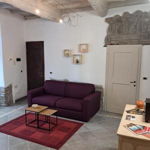 ein Wohnzimmer mit einem lila Sofa und einem Tisch in der Unterkunft Pettinara 21 in Viterbo