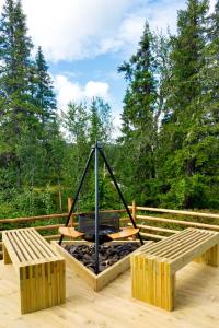 a fire pit on a deck with two benches at New cabin at Skeikampen, perfect for families! in Svingvoll