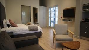 约翰内斯堡The Wantage Suites的一间带床、椅子和电视的卧室