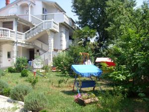 a house with a playground in the yard at Apartment Medulin 1 in Medulin