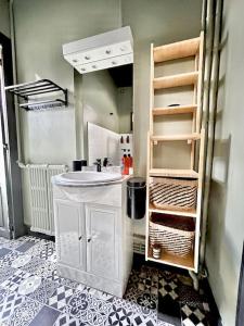 a small bathroom with a sink and a shelf at Appartement ATHOS - Hyper Centre - Familiale in Orléans