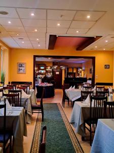 a dining room with tables and chairs in a restaurant at Kolonna Hotel Brigita in Riga