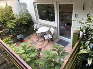 un patio con tavolo e sedie su un portico di Doppelzimmer in Stuttgart-Birkach - Nähe Musicals im SI-Zentrum, Messe, Flughafen, Uni Hohenheim a Stoccarda