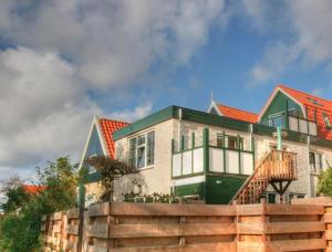 a large house with a fence in front of it at Herenstraat 55 in Den Hoorn