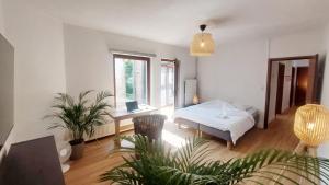een slaapkamer met een bed, een bureau en een raam bij Appartements Entiers - Centre de Tournai in Tournai