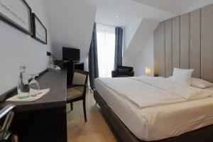 デュッセルドルフにあるDEVIN Art Hotelのベッドと机とパソコンが置かれたホテルの部屋