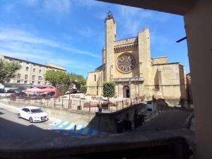 a car parked in front of a building with a clock tower at La terrasse du Clermontais in Clermont-lʼHérault +8 photos