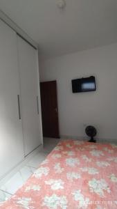 a bedroom with a bed and a tv on the wall at Casa cachoeira dos tourinhos in Massaguassu