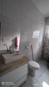 a bathroom with a sink and a toilet at Casa cachoeira dos tourinhos in Massaguassu +13 photos