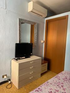 Un dormitorio con un tocador con TV. en La Tana del Granchio, en San Terenzo