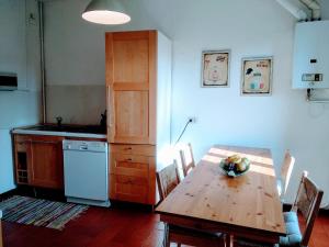a kitchen with a wooden table and a kitchen with a counter at La Corte sul lago app Matilde in Ameno