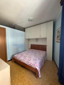 1 dormitorio con 1 cama y armarios blancos en La Tana del Granchio, en San Terenzo