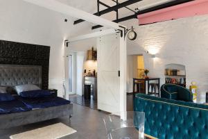 a bedroom with a bed and a blue couch at Wohnen In Der Alten Brauerei in Neuhaldensleben