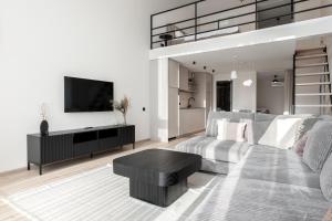 ein Wohnzimmer mit Sofa und Tisch in der Unterkunft Mill Loft in Palanga