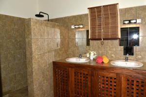 a bathroom with two sinks and a mirror at Résidences-Bel-R in Nosy Be +14 photos