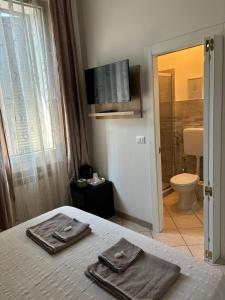 a bedroom with a bed with two towels on it at Affittacamere Home&Stazione Bologna in Bologna