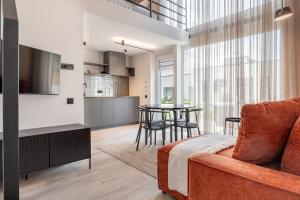 ein Wohnzimmer mit Sofa und Tisch in der Unterkunft Mill Loft in Palanga