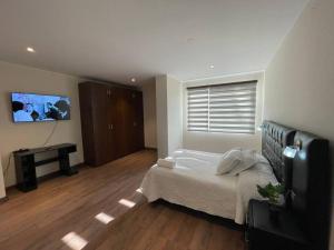 a bedroom with a bed and a flat screen tv at Amplio y comodo apartamento in Calacala
