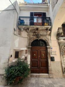 a building with a wooden door and a balcony at casa vacanza pacentro in Pacentro +11 photos