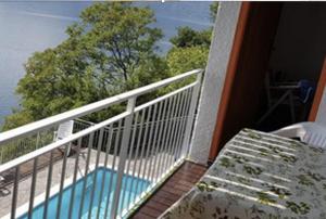 a balcony with a bench and a view of the water at Miralago stunning view over Varenna in Perledo +6 photos