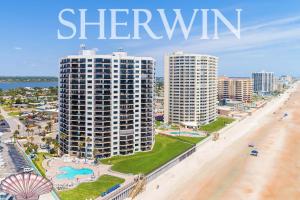 een uitzicht op een strand met twee hoge gebouwen bij "SHERWIN" Coastal Vibes Oceanfront Condominium 301 in Daytona Beach