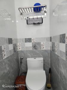 a bathroom with a toilet and a basket on the wall at Nhà du lịch nguyên căn in Khu Chi Lăng