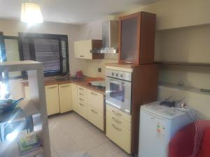 a small kitchen with a stove and a refrigerator at Regina in Acilia