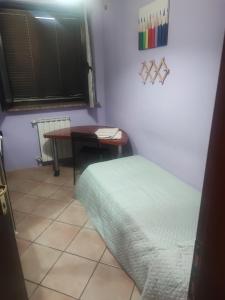 a room with a table and a bed and a desk at Regina in Acilia