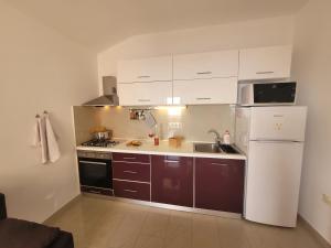 a kitchen with a white refrigerator and a sink at Cosy seaside family apartment Iris in Mandre in Mandre