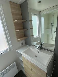 un bagno con lavandino e specchio di Low Budget - 4 persoons chalet aan het Lauwersmeer a Lauwersoog