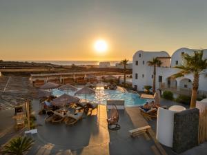 an aerial view of a resort with a pool and the ocean at Amethyst Luxury Suites Oia in Oia