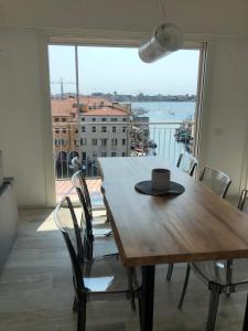- une table et des chaises en bois avec une tasse de café dans l'établissement Chioggia Nice View, à Chioggia